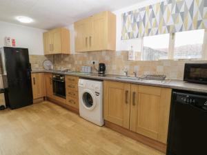a kitchen with a washer and dryer in it at Wingstone Farm Cottage in Newton Abbot