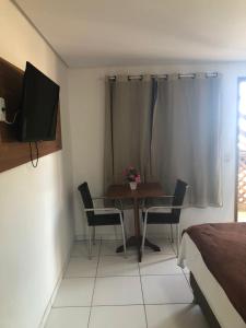 een kamer met een tafel en stoelen en een televisie bij Olinda mar pousada in Olinda