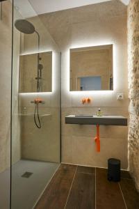 een badkamer met douche, wastafel en spiegel bij Beautiful Art Lovers Apartment in Béziers