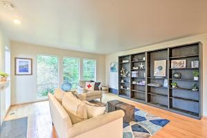 uma sala de estar com duas cadeiras e uma estante de livros em Unique Port Ludlow Home with 3 Decks and Hot Tub! em Port Ludlow