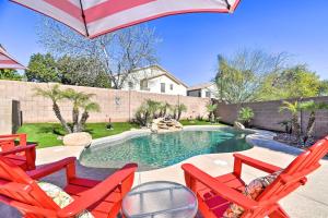 een zwembad met twee rode stoelen en een parasol bij Avondale Home with Private Pool - 15 Mi to Downtown! in Avondale