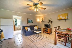 a living room with a blue couch and a ceiling fan at Keaau Apartment on Beautiful Acre with Pool and Deck! in Keaau