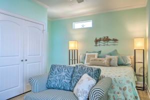 a blue bedroom with a bed and a couch at Furnished Deck + Ocean Views: Surfside Beach Home in Surfside Beach