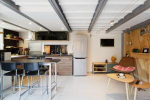 a kitchen with a refrigerator and a table and chairs at Air-conditioned duplex apartment with furnished terrace in the city center in Aix-en-Provence
