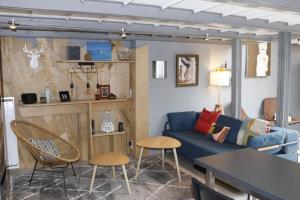 a living room with a blue couch and a table at Air-conditioned duplex apartment with furnished terrace in the city center in Aix-en-Provence