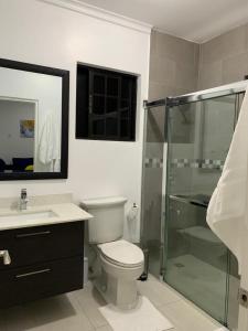 a bathroom with a toilet and a glass shower at Meadows Place in Montego Bay