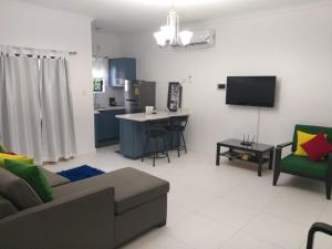 a living room with a couch and a kitchen at Meadows Place in Montego Bay