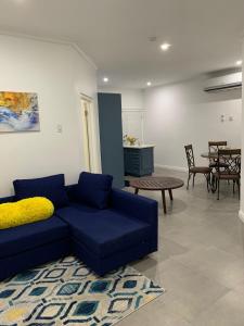 a living room with a blue couch and a table at Meadows Place in Montego Bay