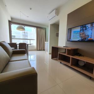 ein Wohnzimmer mit Couch und Flachbildfernseher in der Unterkunft Park Veredas com acesso ao rio no fundo in Rio Quente