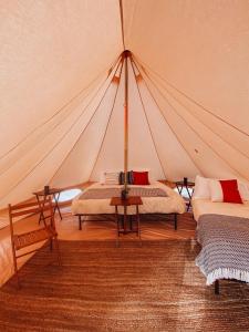 a tent with two beds and a table in a room at Wander Camp Canyonlands in Monticello