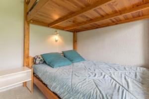 a bedroom with a bed with blue pillows on it at travelski home classic - Résidence Phénix in Le Corbier +17 photos