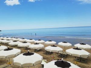 a group of white umbrellas on the beach at TamarHouse Sperlonga Casa Noemi in Sperlonga