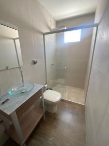 a bathroom with a toilet and a glass shower at Suíte Luxo Refúgio das Ostras in Guarujá