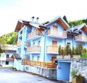 un edificio azul con balcones en un lateral en Mansarda Trentino-Campiglio, en Ossana