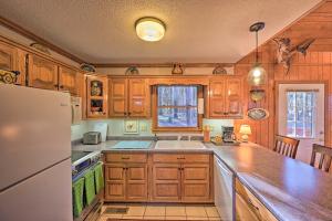 a kitchen with wooden cabinets and a white refrigerator at Serene Cabin with Riverfront Views and Access! in Fayetteville