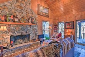 a living room with a stone fireplace in a house at Serene Cabin with Riverfront Views and Access! in Fayetteville