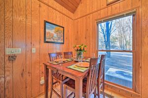 a dining room with a table and chairs and a window at Serene Cabin with Riverfront Views and Access! in Fayetteville