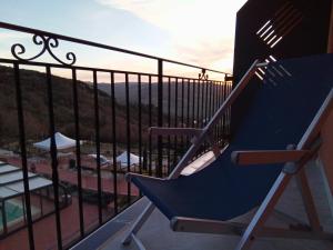 a blue chair on a balcony with a view at Resort San Nicola - Restaurant and Wellness Fitness in Polizzi Generosa