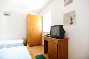 una camera con letto e TV su un comò di Apartments Rejo a Okrug Donji