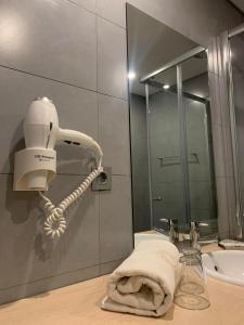 a white hair dryer sitting on a bathroom sink at Hotel Da Luz in Santa Maria