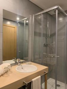 a bathroom with a sink and a shower at Hotel Da Luz in Santa Maria