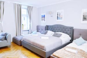 um quarto com 2 camas e uma cadeira em 21 Floriańska Street Apartments em Cracóvia