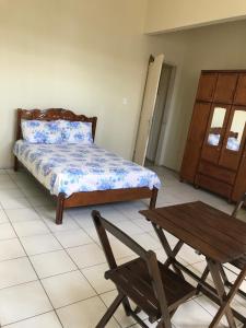 a bedroom with a bed and a chair and a table at Bela Vista in São Luís