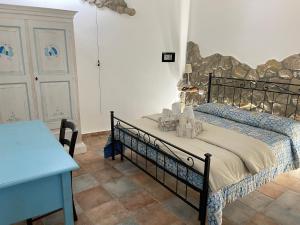 een slaapkamer met een bed en een blauwe tafel bij Canne al vento in Quartu SantʼElena