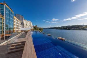 a swimming pool on the side of a river at Pestana Douro Riverside in Porto