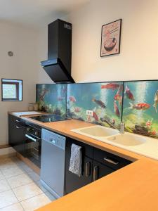 a kitchen with an aquarium wall with two sinks at Le KYOTO Deco ZenCenterFIBREparking in Chalon-sur-Saône