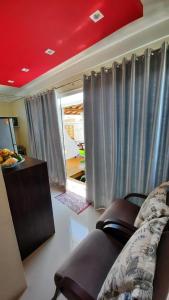 a living room with a couch and gray curtains at Bangalô in Porto Seguro