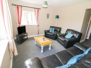 een woonkamer met lederen meubels en een salontafel bij Island View in Ardmore