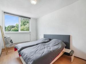 a bedroom with two beds and a window at Serene Bungalow in Landgraaf with Terrace and Nature Garden in Landgraaf