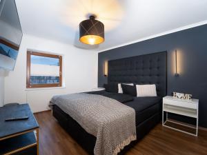 ein Schlafzimmer mit einem schwarzen Bett und einem Fenster in der Unterkunft High quality apartment with whirlpool in Dorf