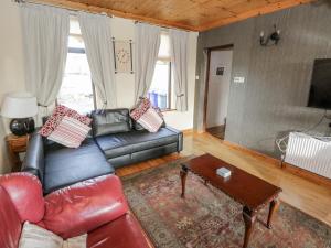 een woonkamer met een leren bank en een salontafel bij Tullavilla in Riverstown