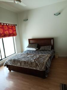 a bedroom with a bed and a window at Bhurban 2bed townhouse with a lawn in Bhurban