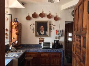 a kitchen with a portrait of a woman on the wall at Hotel Mi Casita in Taxco de Alarcón