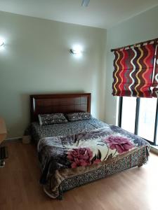 1 dormitorio con 1 cama con colcha de flores en Bhurban 2bed townhouse with a lawn, en Bhurban