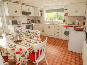 a kitchen with a table with a flowered table cloth at Limestone Cottage in Ennis