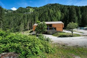 a brick building in the middle of a forest at Vallesinella Hotel Restaurant Bar in Madonna di Campiglio