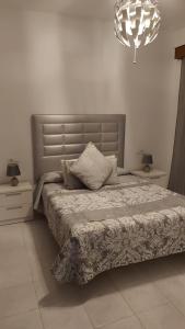 ein Schlafzimmer mit einem Bett und einem Kronleuchter in der Unterkunft San Francisco's House in Medina-Sidonia
