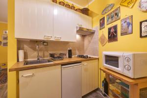 una pequeña cocina con fregadero y microondas en Annina's House Varenna Historic Centre, en Varenna
