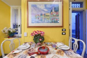 una mesa de comedor con un jarrón de flores. en Annina's House Varenna Historic Centre, en Varenna