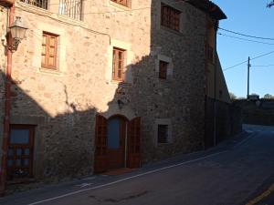 a large stone building with a door on a street at Apartament els Masovers in La Pera