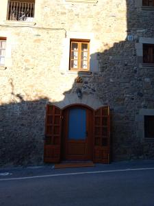 un edificio con una puerta de madera y una ventana en Apartament els Masovers en La Pera