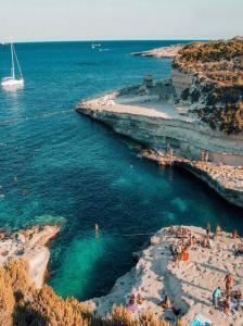 eine Gruppe von Menschen im Wasser an einem Strand in der Unterkunft Mon-Chery in San Ġwann