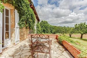 a bench sitting on a stone walkway next to a building at Villa charmante à Dunes avec piscine privée in Dunes