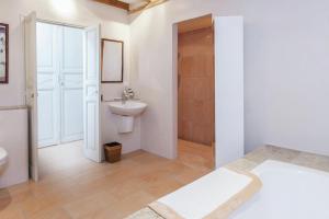 a white bathroom with a sink and a toilet at Villa charmante à Dunes avec piscine privée in Dunes +25 photos