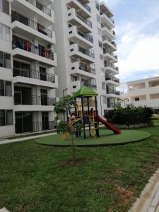 a playground in front of a apartment building at Apartamento vacacional amplio, cómodo y tranquilo. in Ricaurte