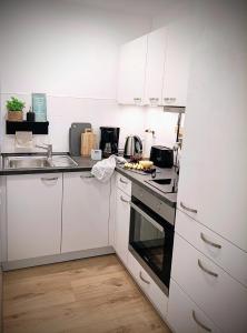 a kitchen with white cabinets and a stove top oven at Baumkrone in Altenau